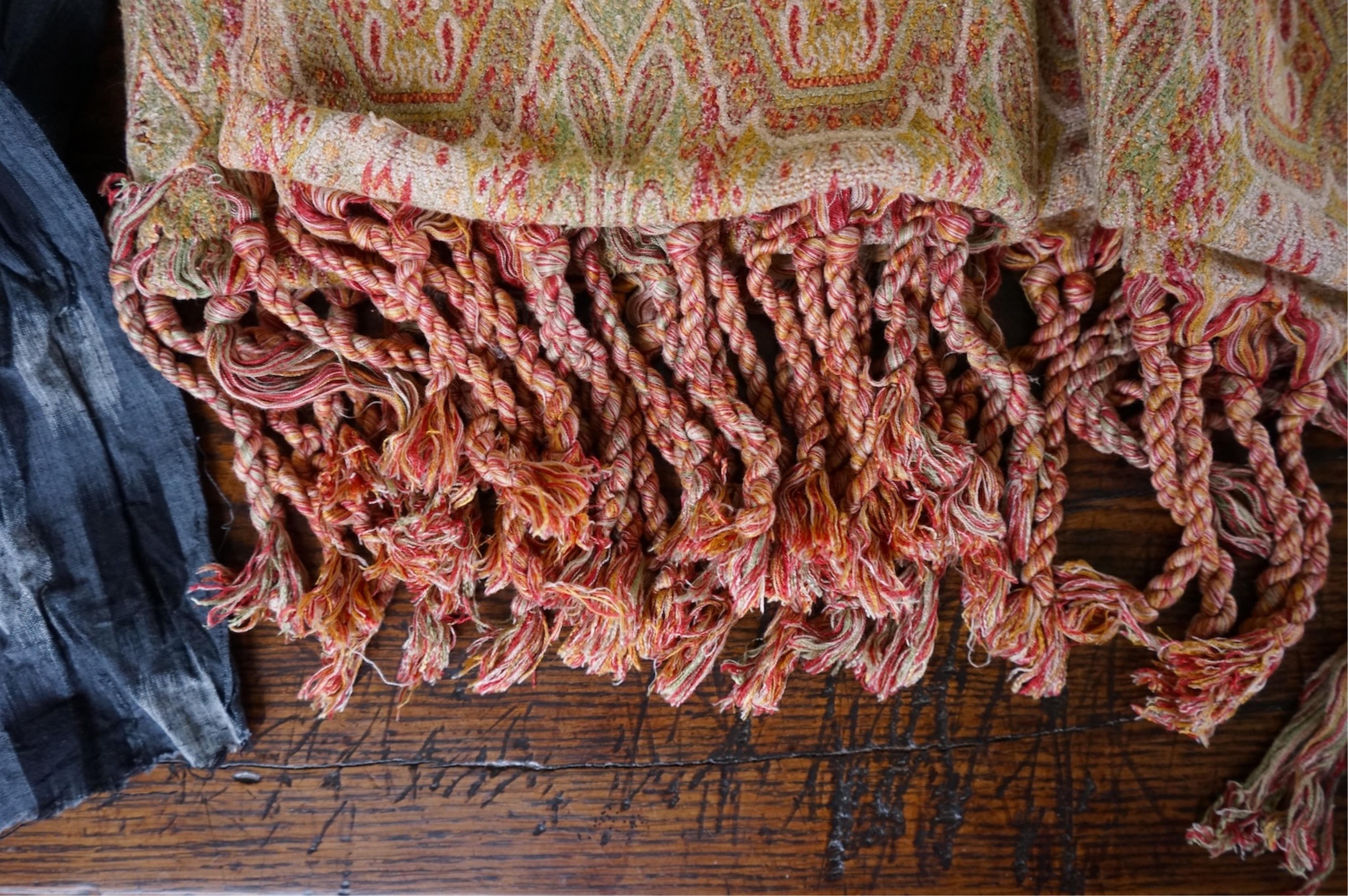 A long narrow length of grey Ikat woven fabric, a roll of Indian mirrored edging, a geometric batik printed length and a woven paisley ‘style’ tasselled stole. (4). Batik 392cm long x 108cm wide., Condition - good, all a